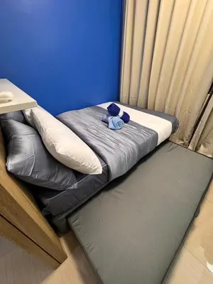 a teddy bear sitting on a bed in a room at Iris Suites in Manila
