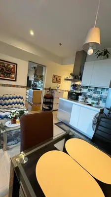 a kitchen and living room with a table and chairs at Jules Cozy StayCay II in Manila