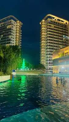 a view of two buildings and the water at night at Jules Cozy StayCay II in Manila