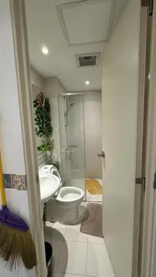 a bathroom with a toilet and a shower and a sink at Jules Cozy StayCay II in Manila