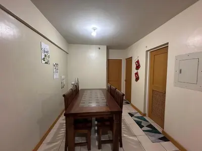 a dining room with a wooden table and chairs at Staycation in Taguig in Manila