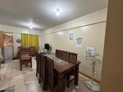 a dining room with a table and a fan at Staycation in Taguig in Manila