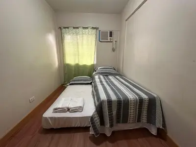 a small bedroom with a bed with two towels on it at Staycation in Taguig in Manila