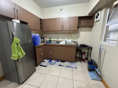 a kitchen with a refrigerator and a tile floor at Staycation in Taguig in Manila
