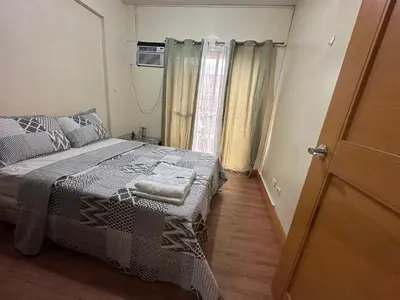 a small bedroom with a bed and a window at Staycation in Taguig in Manila
