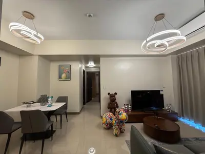 a living room with a dining table and a television at Luxurious Style Apartment cross to Okada and near City of Dreams, Solaire, MOA, and Airport in Manila