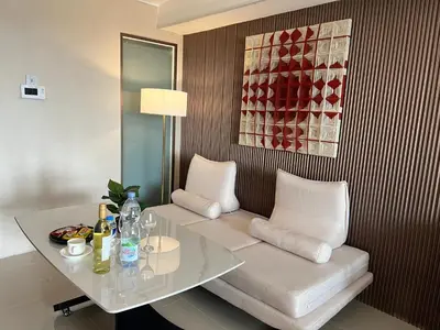 a living room with a table and a white couch at Luxurious Style Apartment cross to Okada and near City of Dreams, Solaire, MOA, and Airport in Manila