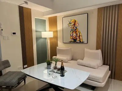 a living room with a white table and a chair at Luxurious Style Apartment cross to Okada and near City of Dreams, Solaire, MOA, and Airport in Manila