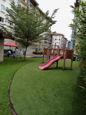 a playground with a red slide in a park at Cali Suite - Nuvali in Pitland