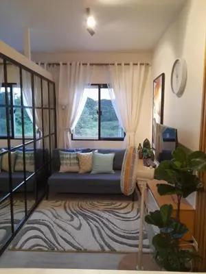 a living room with a couch and a window at Cali Suite - Nuvali in Pitland