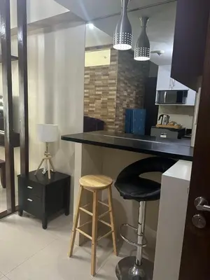 a kitchen with a counter and two stools in it at One Palm Tree by Melba STUDIO TYPE in Manila