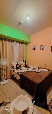 a bedroom with two beds and a green wall at G and A CONDOTELS in Manila