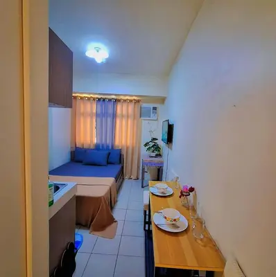 a small room with a bed and a table at G and A CONDOTELS in Manila