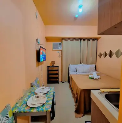 a small room with two beds and a table in it at G and A CONDOTELS in Manila