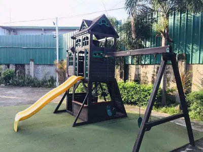 a playground with a slide and a play structure at Fiona Apartment in Manila