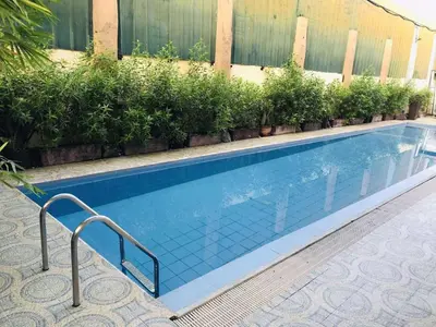 a swimming pool with a staircase next to a building at Fiona Apartment in Manila