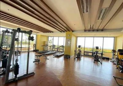 a gym with several treadmills and machines in a room at Cozy Studio typeunit in Manila