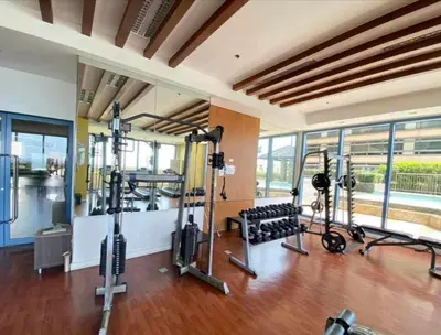 a gym with several treadmills and machines in a room at Cozy Studio typeunit in Manila