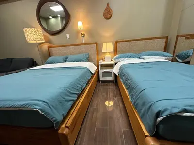 two twin beds in a bedroom with a mirror at 2 Bed Suite at Air Residences Condo, Ayala Ave Makati in Manila