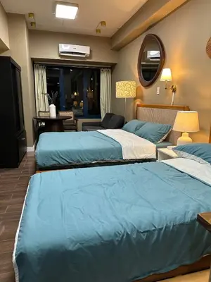 a bedroom with two beds and a mirror at 2 Bed Suite at Air Residences Condo, Ayala Ave Makati in Manila