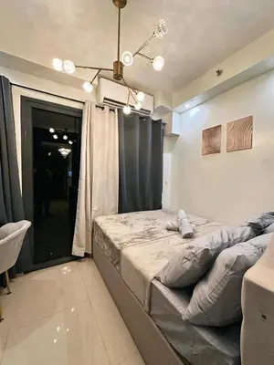 a large bed in a room with a window at Château Zen&Kat in Manila
