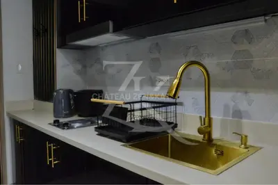 a kitchen sink with a dish drying rack next to it at Château Zen&Kat in Manila