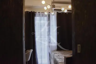 a room with a window with black curtains and a chandelier at Château Zen&Kat in Manila