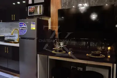 a kitchen with a large television and a counter with candles at Château Zen&Kat in Manila