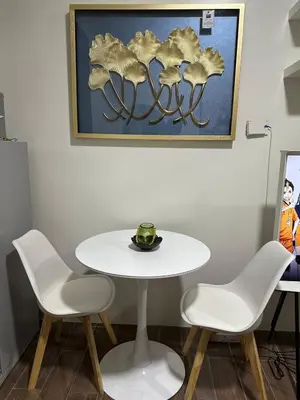 a white table and chairs in a room with a painting at A King-size bed at Air Residences Condo, Ayala Ave, Makati in Manila
