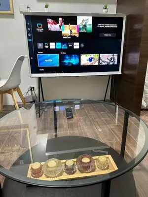 a glass table with donuts on top of it in front of a tv at A King-size bed at Air Residences Condo, Ayala Ave, Makati in Manila