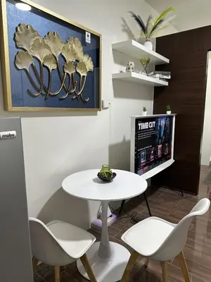 a room with a table and chairs and a tv at A King-size bed at Air Residences Condo, Ayala Ave, Makati in Manila