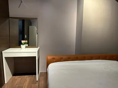 a bedroom with a bed and a table with a mirror at Air Residences Apartment, Ayala Avenue Makati in Manila