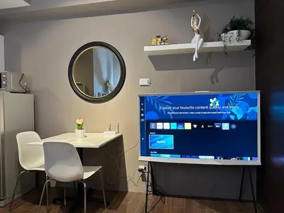 a room with a tv and a table and a mirror at Air Residences Apartment, Ayala Avenue Makati in Manila