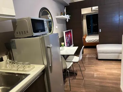 a small kitchen with a sink and a microwave at Air Residences Apartment, Ayala Avenue Makati in Manila