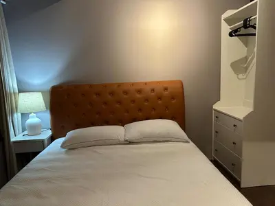 a bedroom with a bed with a headboard and a lamp at Air Residences Apartment, Ayala Avenue Makati in Manila