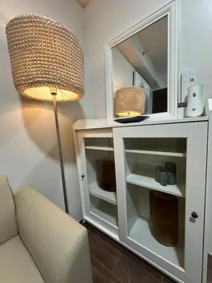 a white cabinet with a lamp and a couch at King size bed at Air Residences Condo, Ayala Ave, Makati in Manila
