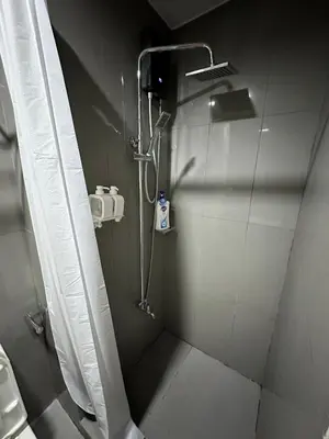 a shower in a bathroom with a shower curtain at King size bed at Air Residences Condo, Ayala Ave, Makati in Manila