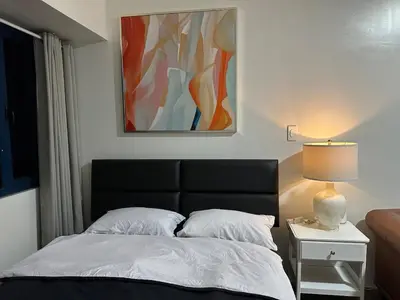 a bedroom with a bed and a painting on the wall at Suite at Air Residences Condo, Ayala Ave Makati in Manila