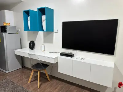 a white desk with a flat screen tv on a wall at Suite at Air Residences Condo, Ayala Ave Makati in Manila