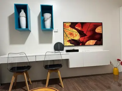 two chairs and a tv on a white counter at Suite at Air Residences Condo, Ayala Ave Makati in Manila