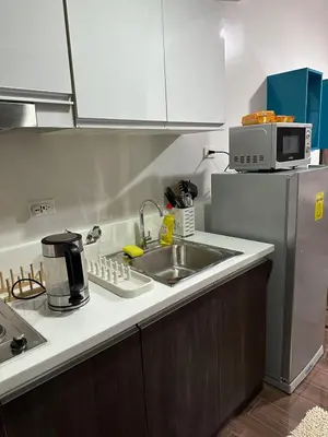 a kitchen with a sink and a refrigerator at Suite at Air Residences Condo, Ayala Ave Makati in Manila