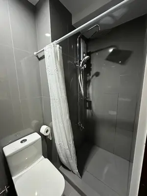 a bathroom with a shower and a white toilet at Suite at Air Residences Condo, Ayala Ave Makati in Manila