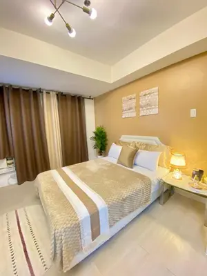a bedroom with a large bed and a table at Azure Staycation PH in Manila