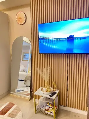 a living room with a large screen tv on a wall at Azure Staycation PH in Manila