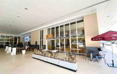 a building with tables and chairs in a mall at Kate's Haven Jazz Residences Makati, Manila in Manila