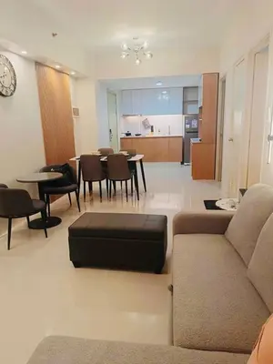 a living room with a couch and a table and chairs at Kate's Haven Jazz Residences Makati, Manila in Manila