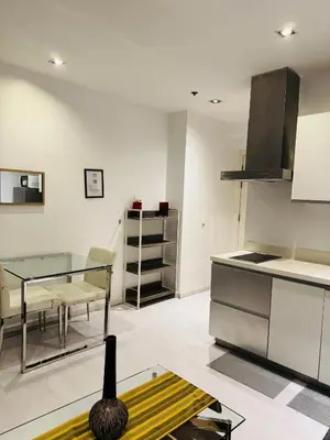 a kitchen with a glass table and some chairs at Gramercy Residences Studio With Balcony City View in Manila