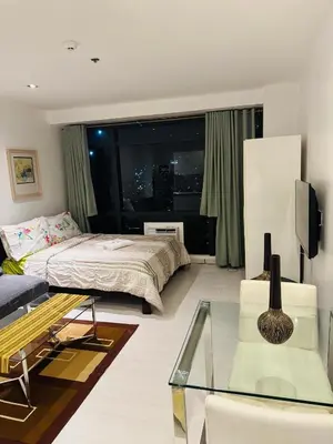 a bedroom with a bed and a large window at Gramercy Residences Studio With Balcony City View in Manila