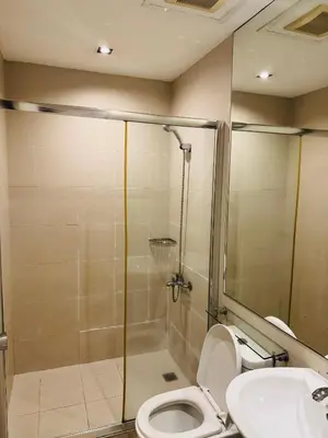 a bathroom with a shower and a toilet and a sink at Gramercy Residences Studio With Balcony City View in Manila