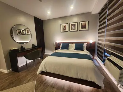a bedroom with a large bed and a mirror at Prime Location Walk to Nightlife! The Gramercy in Manila